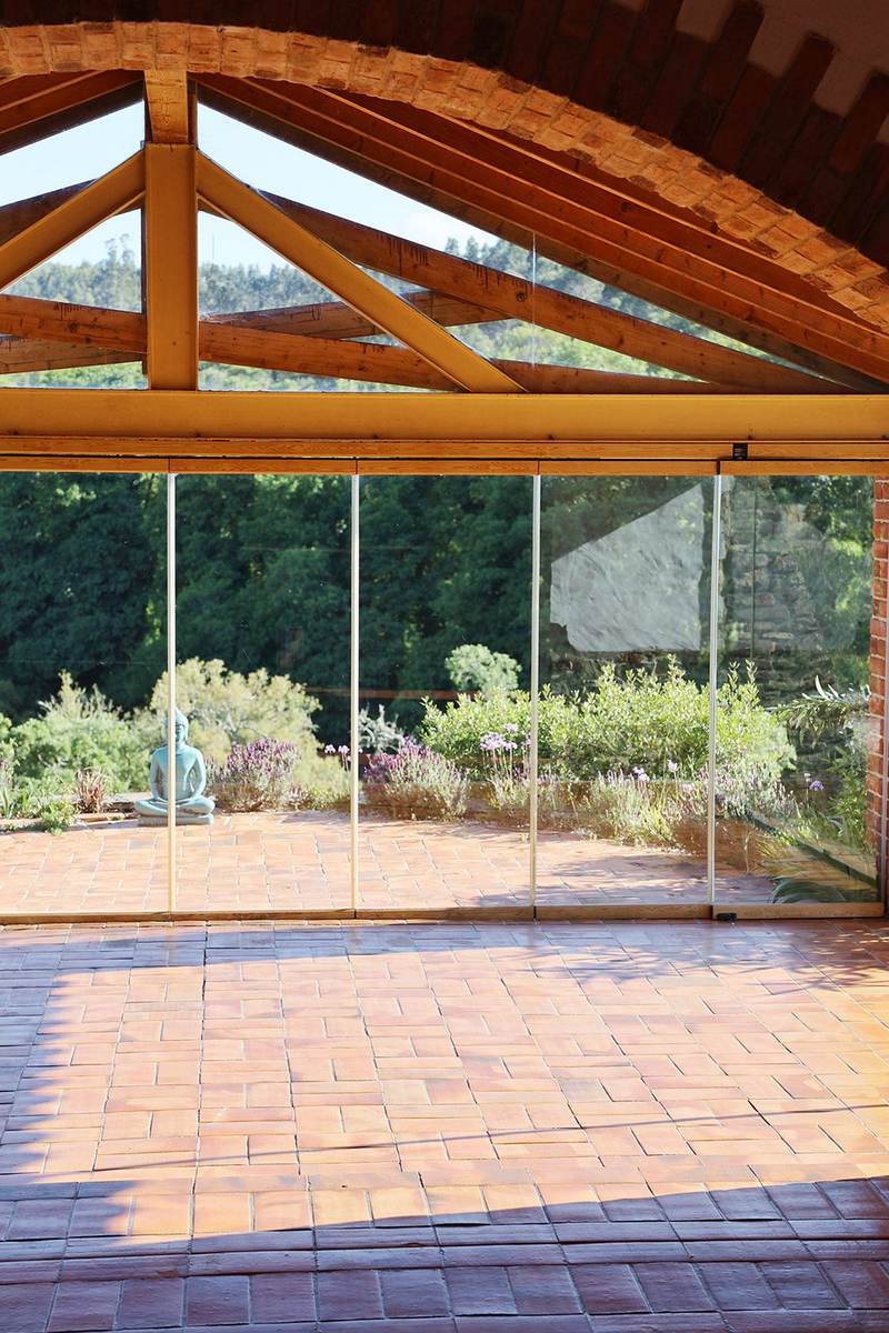 The main room, wooden beams and a glass wall onto the garden